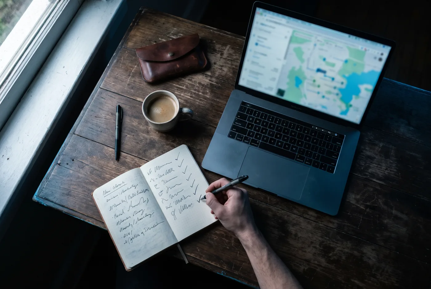 Zaakvoerder werkt een checklist af naast laptop en koffie