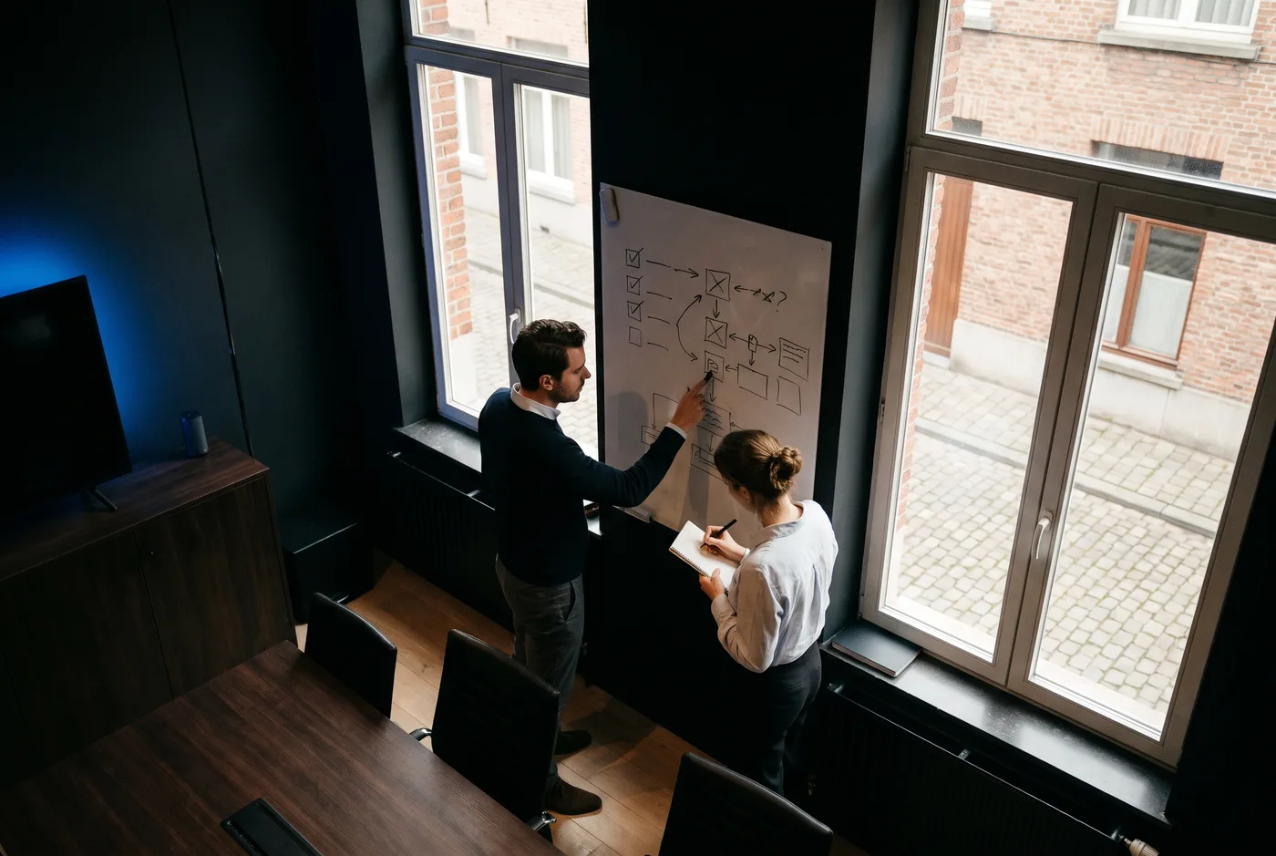 Twee collega's overleggen over een lijst met vragen voor een SEO bureau