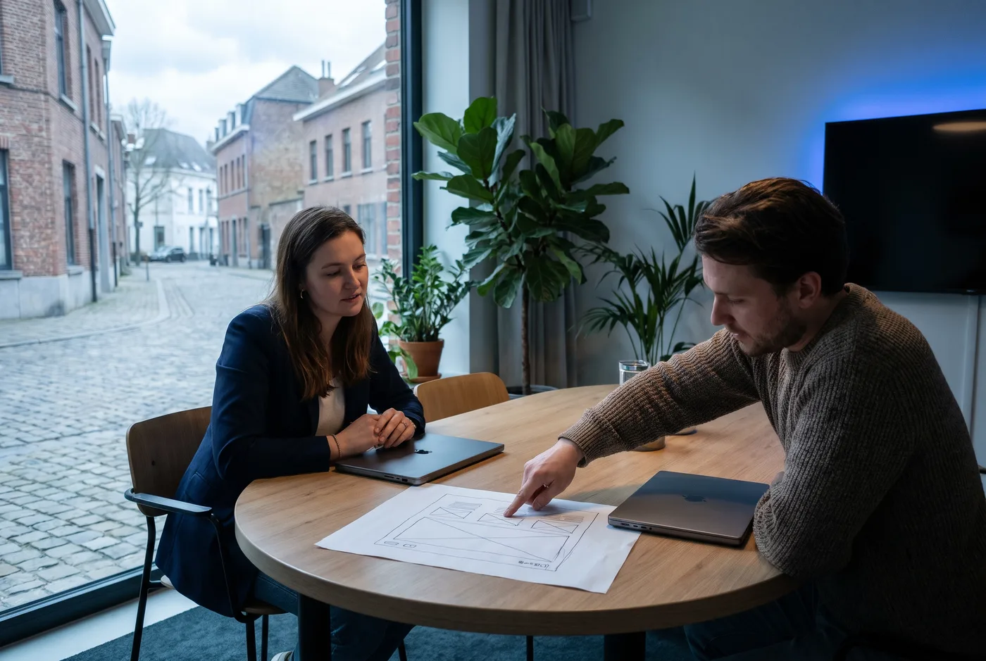 Ondernemer en adviseur bespreken een online strategie aan een vergadertafel